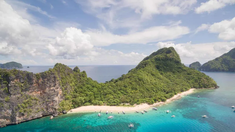Limestone cliffs above a sheltered cove at Matinloc on the Tour C el nido island hopping tour, Bacuit Bay, Palawan